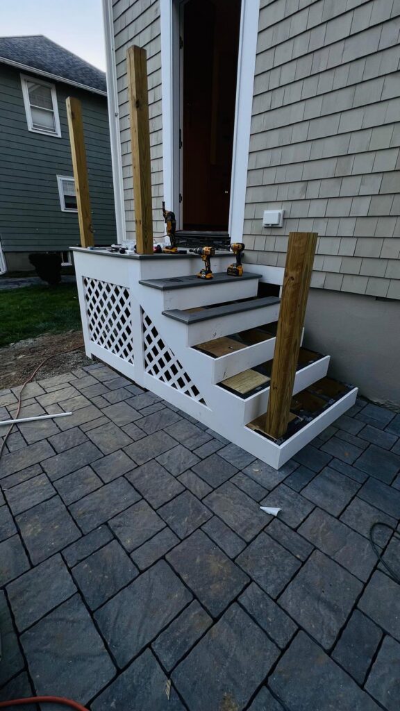 Exterior entry stairs under construction with lattice skirting
