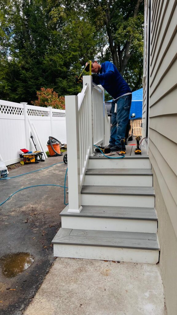 Carpenter measuring a new exterior stair railing