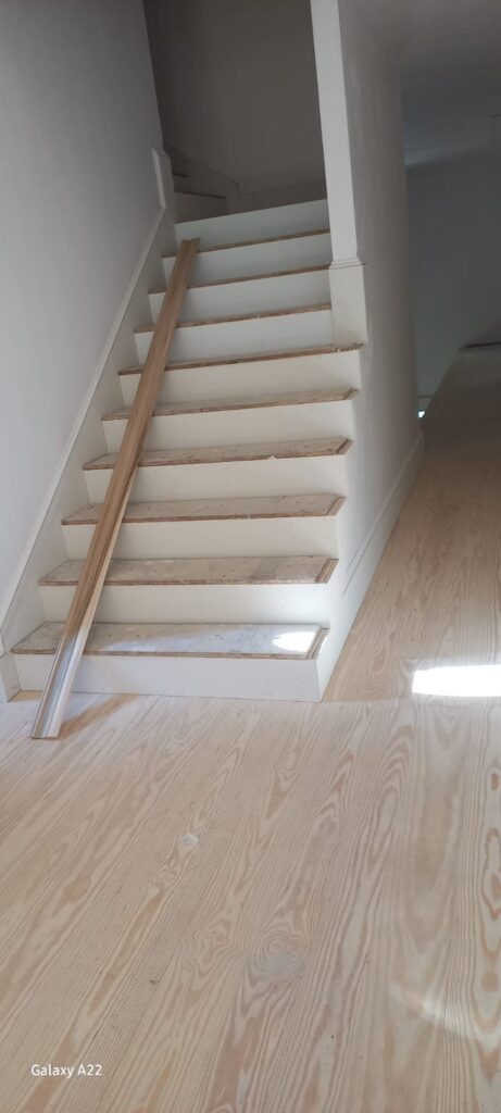 Interior staircase before renovation with worn subfloor treads