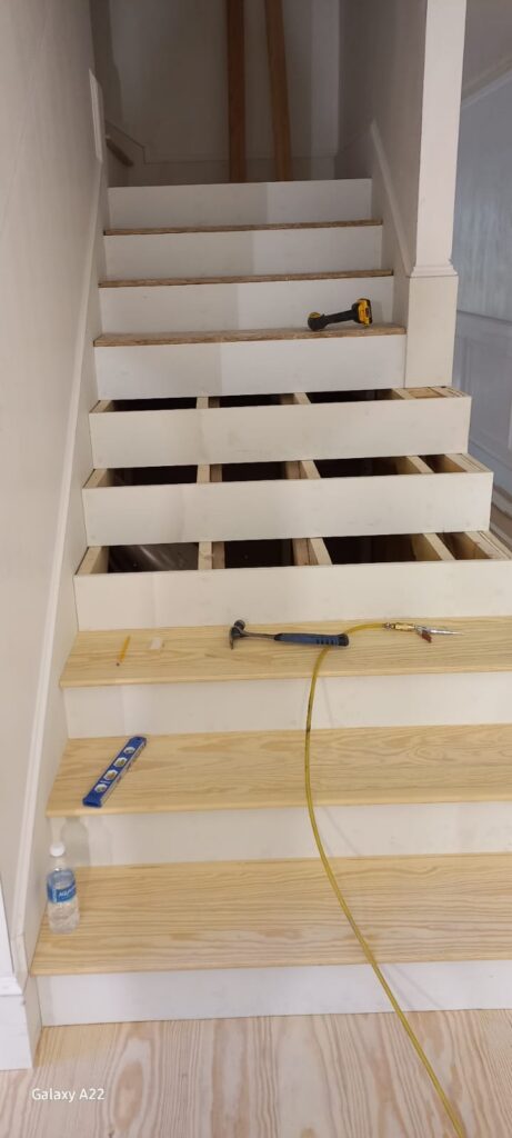 Stair tread installation in progress with tools on the steps